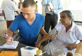 Vrijwilligerswerk in Sri Lanka:Een verpleegkunde vrijwilliger help een patient in Sri Lanka bij het meten van de bloeddruk. Een verpleegkunde vrijwilliger help een patient in Sri Lanka bij het meten van de bloeddruk.
