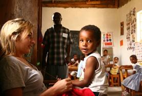 Sociaal vrijwilligerswerk met kinderen in het buitenland:Een vrijwilliger werkt met kinderen in een dagopvangcentrum in Tanzania. Een vrijwilliger werkt met kinderen in een dagopvangcentrum in Tanzania.